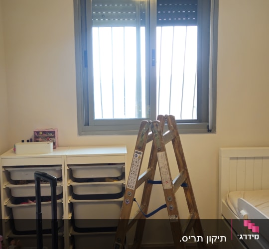 סולם ותיק כלי עבודה של בעל מקצוע במהלך תיקון תריס גלילה בחלון